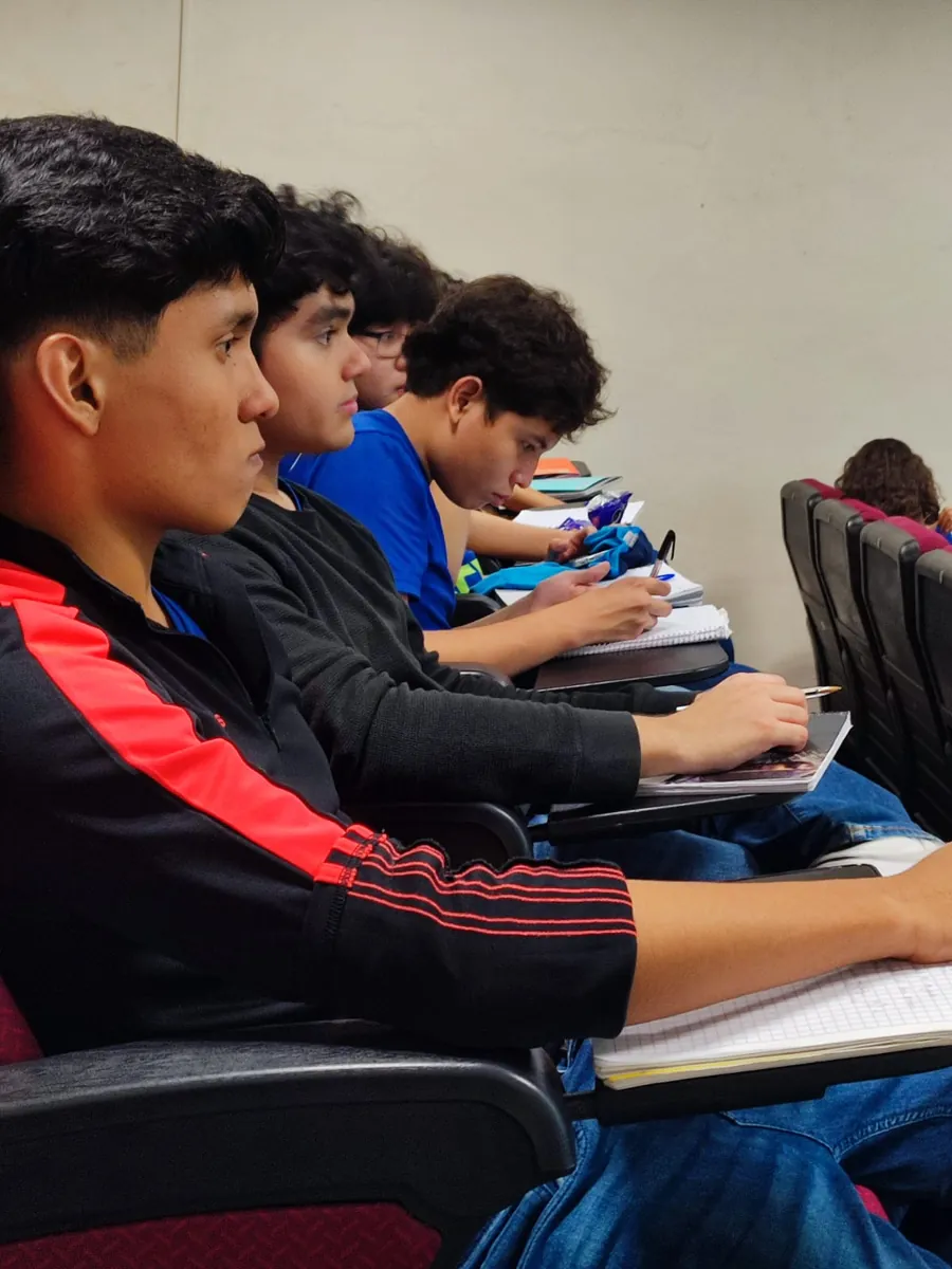 Estudiantes de Bachillerato de Colegio Latino tomando notas durante una clase en el auditorio