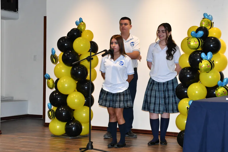 Estudiantes de Bachillerato de Colegio Latino participando en el concurso Spelling Bee frente a un micrófono