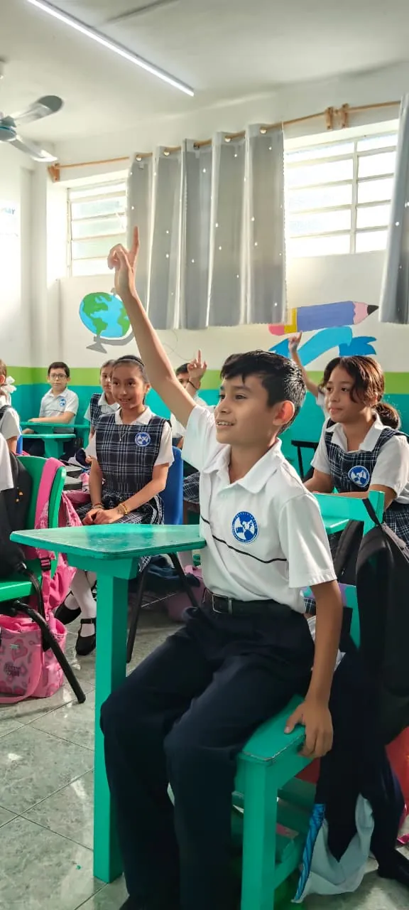 Estudiante de Primaria de Colegio Latino levantando la mano para participar en clase