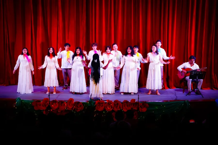 Estudiantes de Secundaria de Colegio Latino cantando en un festival escolar sobre un escenario